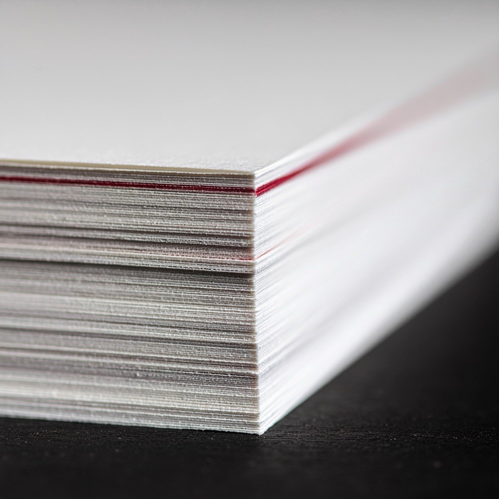 Een stapel papier op de snede, met een rood vel ertussen